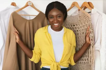 African American Shopaholic Woman Posing Among Clothes In Wardrobe Indoor