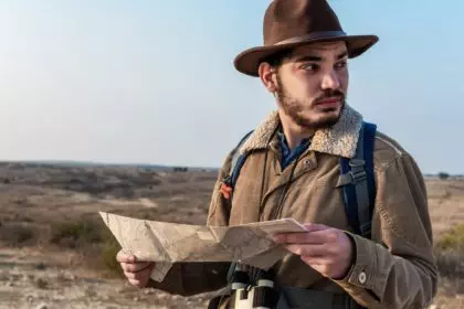 Closeup of a Male hiker using a map to locate the destination